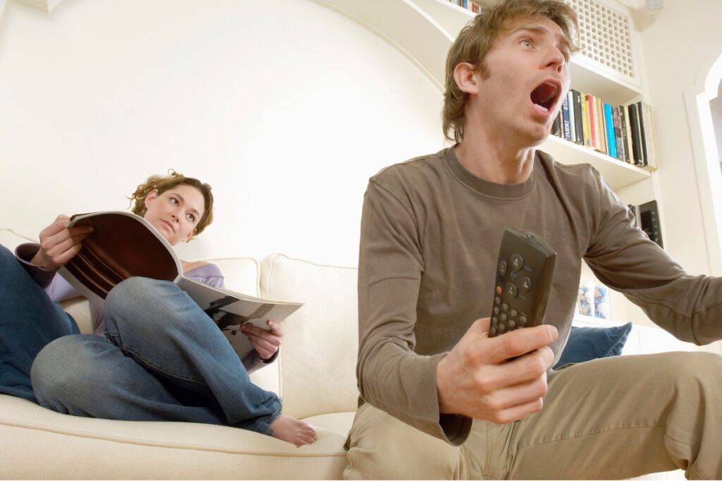 Couple reading a magazine and watching TV
